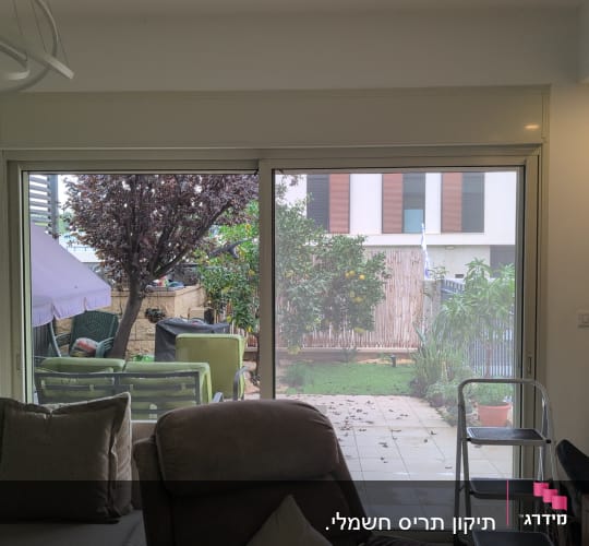 חלון זכוכית גדול עם נוף לגינה חיצונית